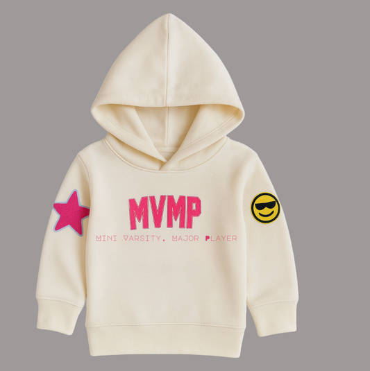 Cream hoodie with pink text and sleeve patches on a grey background