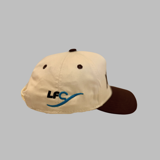 Beige and brown cap with a logo on a gray background